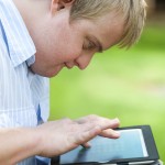 Kid with down syndrome playing on tablet.